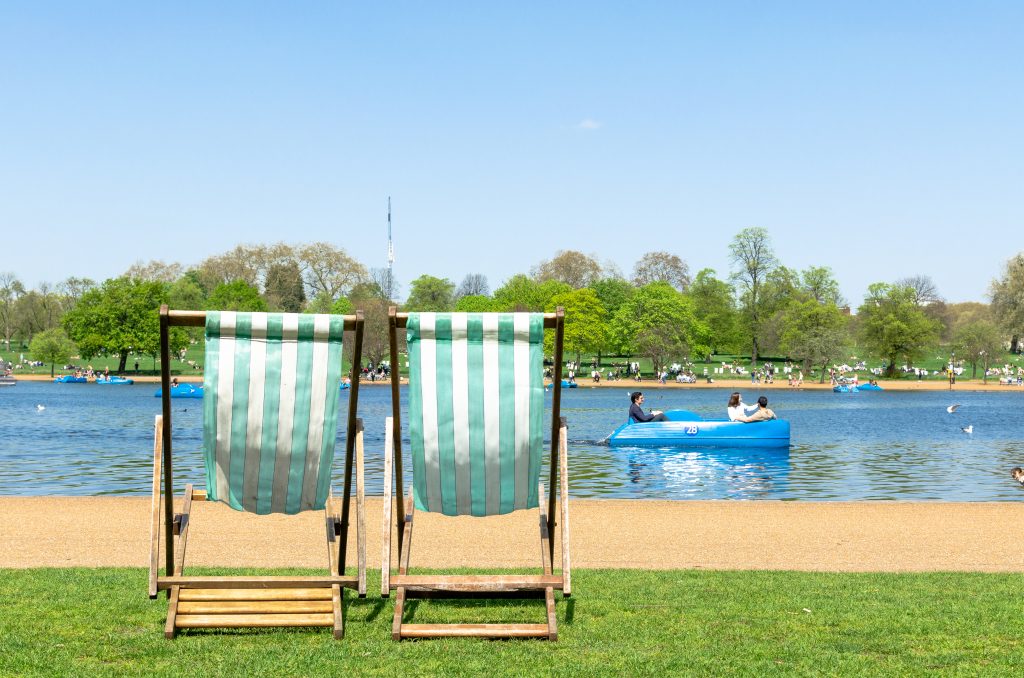 A photo of two chairs in the middle of Hyde Park, facing the Serpentine.